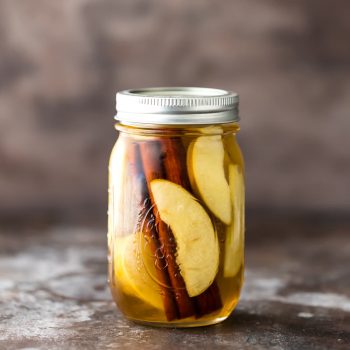 Homemade Apple Pie Vodka is an easy gift idea for Fall! Simple Apple Pie Vodka makes the best fall cocktail with Apple Pie Spritzer! Apple Pie Vodka, Apple Cider, and Club Soda! SO DELISH!