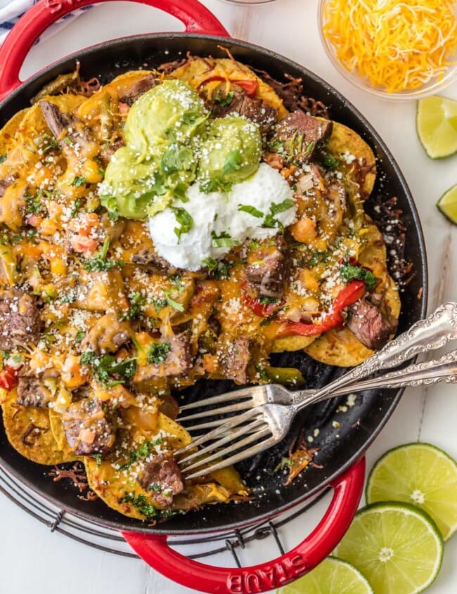 SKILLET STEAK FAJITA NACHOS are a must make for tailgating, the Super Bowl, or anytime! These delicious steak nachos are loaded with peppers, onion, cheese, and marinated steak. Possibly the best nachos ever!
