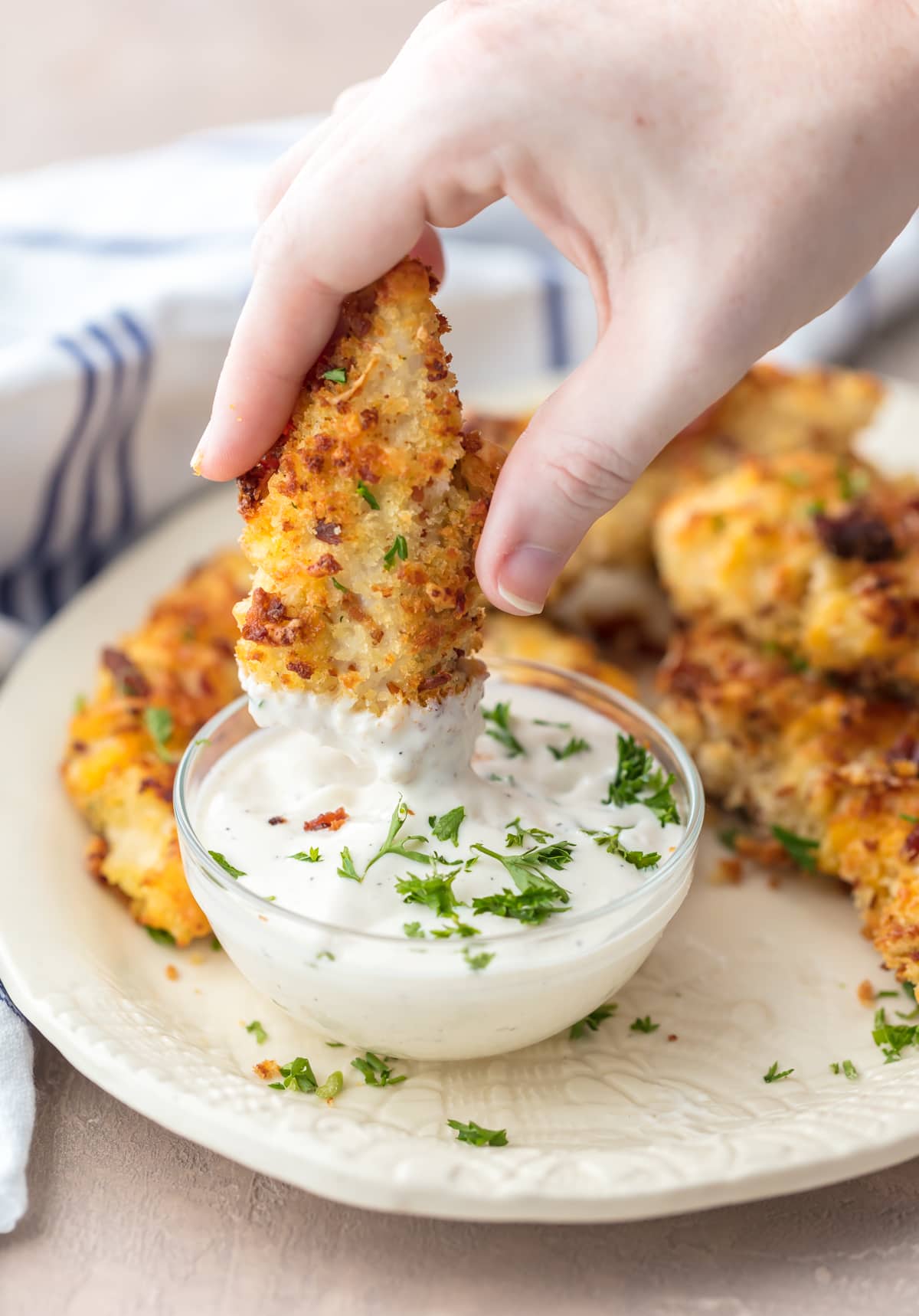 Dipping a baked chicken tender in ranch