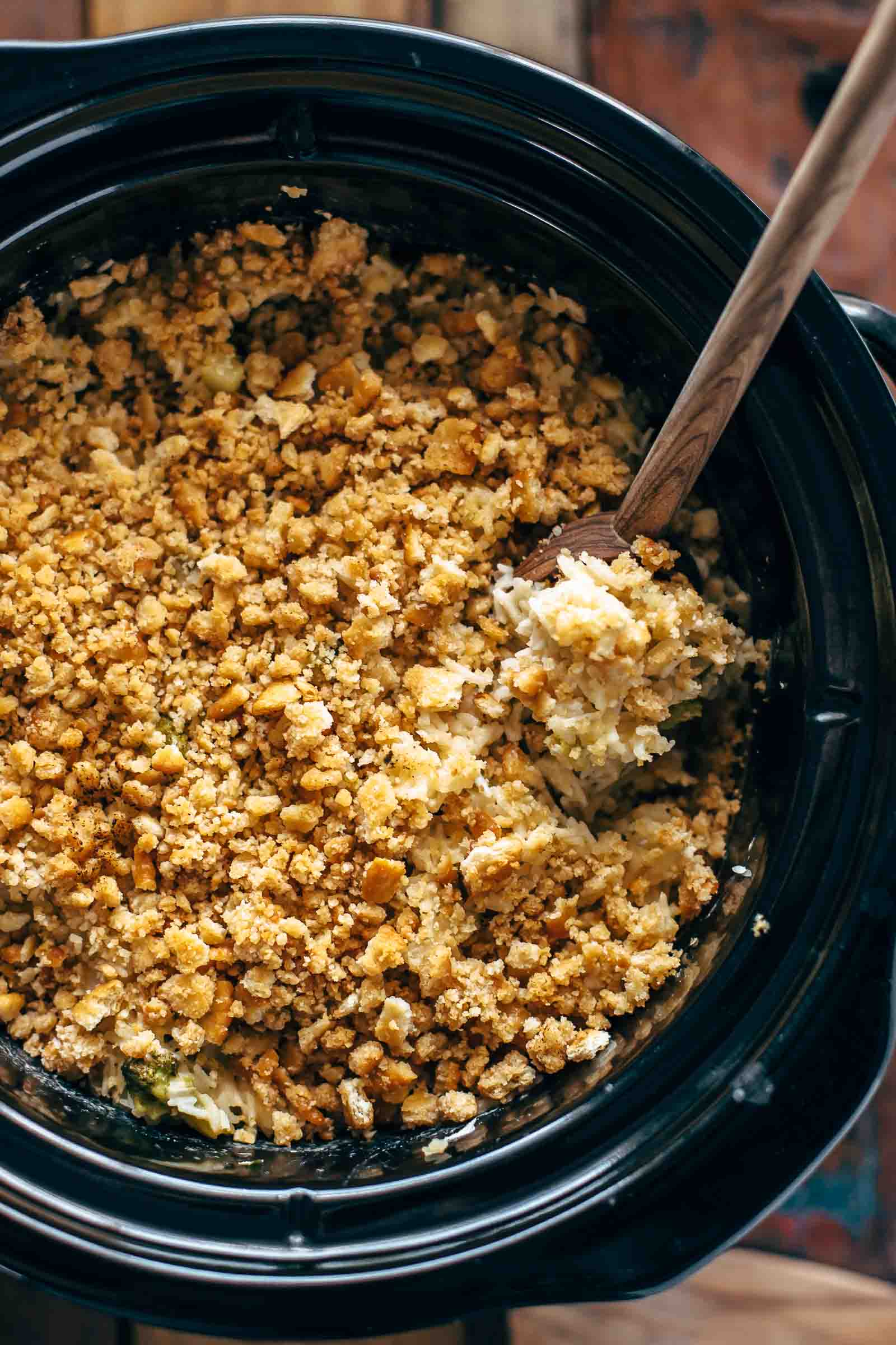 spoon digging in to velveeta broccoli rice casserole in a crock pot