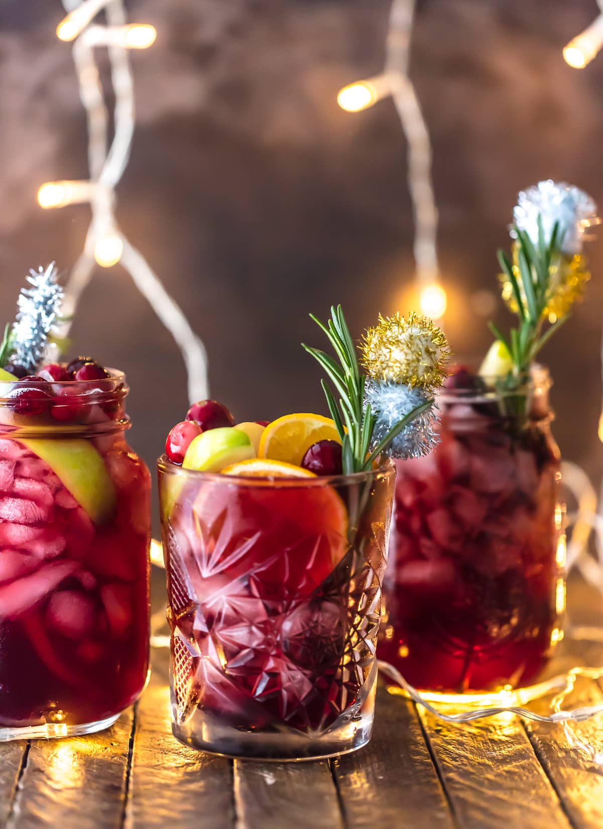 HOLIDAY SANGRIA is the perfect Christmas cocktail! It's made with red wine, vodka, sparkling apple cider, and several juices. Better yet, this Christmas Sangria is gluten free. You'll be the star of any holiday party with this recipe. Cheers! Christmas cocktail recipe in three glasses