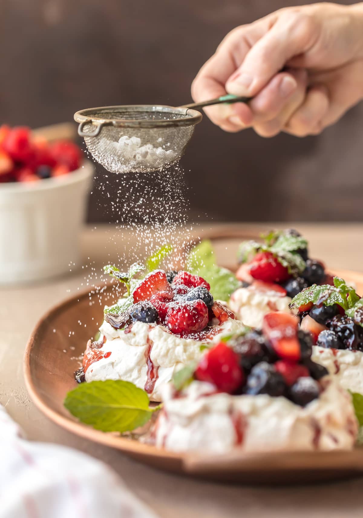 Sprinkled powdered sugar on top of mini pavlova desserts