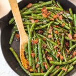 burbon green beans and bacon in skillet with wooden spoon