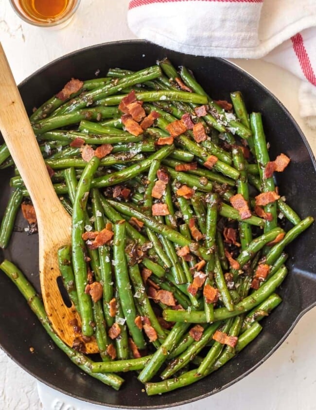 Skillet Green Beans are an easy way to make some veggies for your meal. These Bourbon Green Beans with Bacon add some spice, flair, and beauty to any holiday table! It's the ultimate Thanksgiving side dish that's SO full of flavor, you'll be blown away! 