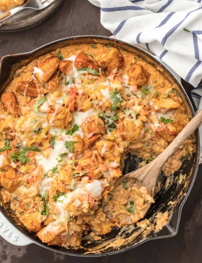 Chicken con Queso (Skillet Queso Chicken) is the ultimate one pot meal! Cheesy rice loaded with cilantro, pico de gallo, green chiles, and cream topped with taco spiced chicken. This one pan recipe is so cheesy, easy, and amazing. I used to always order Pollo con Queso at Mexican Restaurants and now I can easily make it at home. Chicken and Cheese...is there anything better?