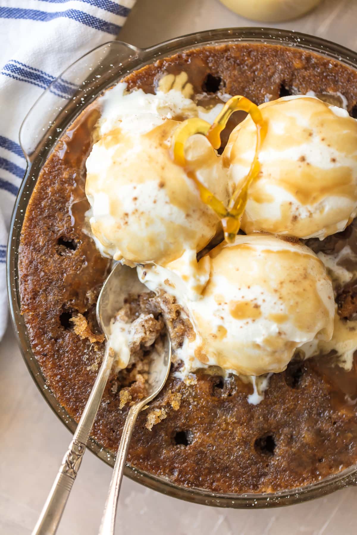 Toffee Pudding Poke Cake in a baking dish, topped with ice cream