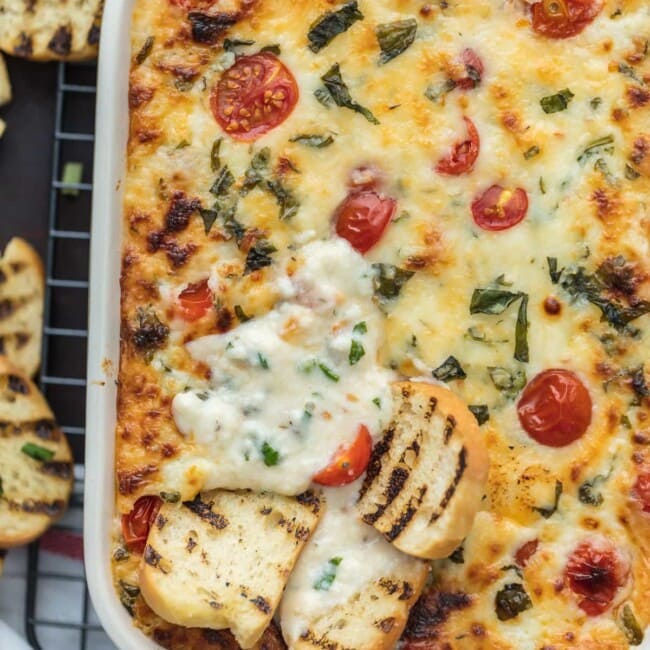 Tomato Mozzarella Caprese Dip is the ultimate EASY party dip for any occasion! This cheesy dip is perfect for any celebration, tailgating, and especially the Super Bowl. Best cheese dip recipe ever!
