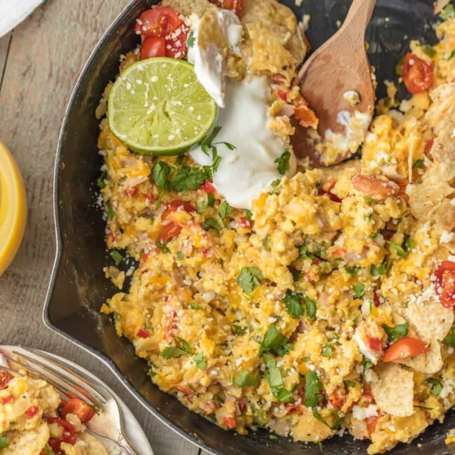 cheesy migas in skillet with wooden spoon