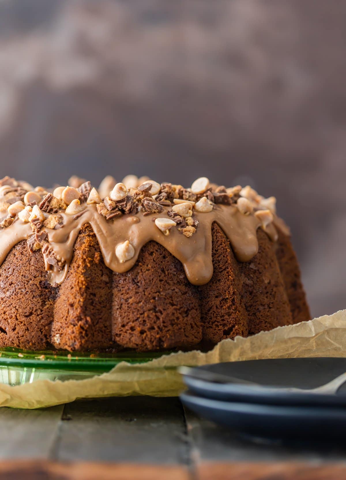 This CHOCOLATE PEANUT BUTTER CAKE is the ultimate bundt cake recipe! The cake is made with peanut butter AND peanut butter cups, and then topped with a decadent peanut butter icing. All that peanut butter makes this indulgent cake the most amazing peanut butter chocolate cake recipe! Chocolate Peanut Butter Cake recipe topped with peanut butter frosting