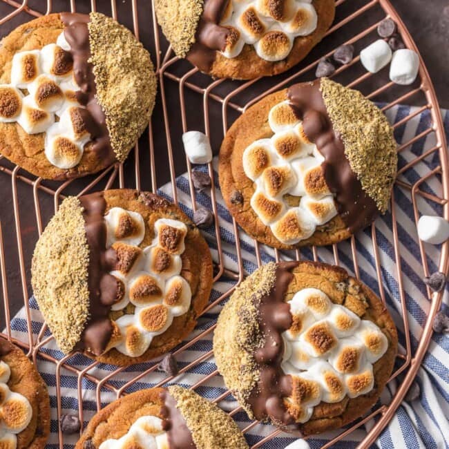 S'mores Cookies are one of the BEST Easy Cookie Recipes I have ever made (or tried!). These Easy Smores Cookies are a favorite at our house for Christmas or any time of year. It can be our little secret that they're made with pre-made refrigerated chocolate chip cookie dough, dipped in milk chocolate, then graham cracker crumbs. Everything you love about S'mores in cookie form. DIVINE! Easy S'more Cookies for the win!