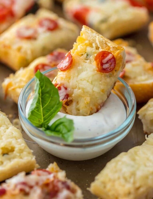 FRENCH BREAD PIZZA BITES are the easiest and tastiest cheesy appetizer! These mini french bread pizzas are loaded with garlic butter, cheese, and all of your favorite toppings. They make a great appetizer (the perfect party food), but we may just eat them as an entire meal!
