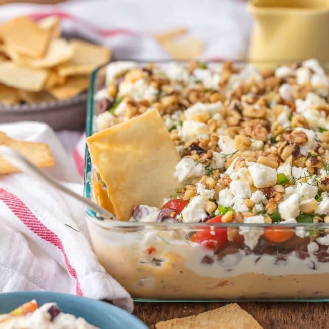 7 Layer GREEK DIP is a fun twist on a classic appetizer. This delicious 7 layer dip recipe is the perfect shareable appetizer for Christmas, New Year's Eve, or for tailgating. Seven delicious layers of hummus, greek yogurt, feta, and all of the best Mediterranean inspired ingredients make it a seriously addicting dip!