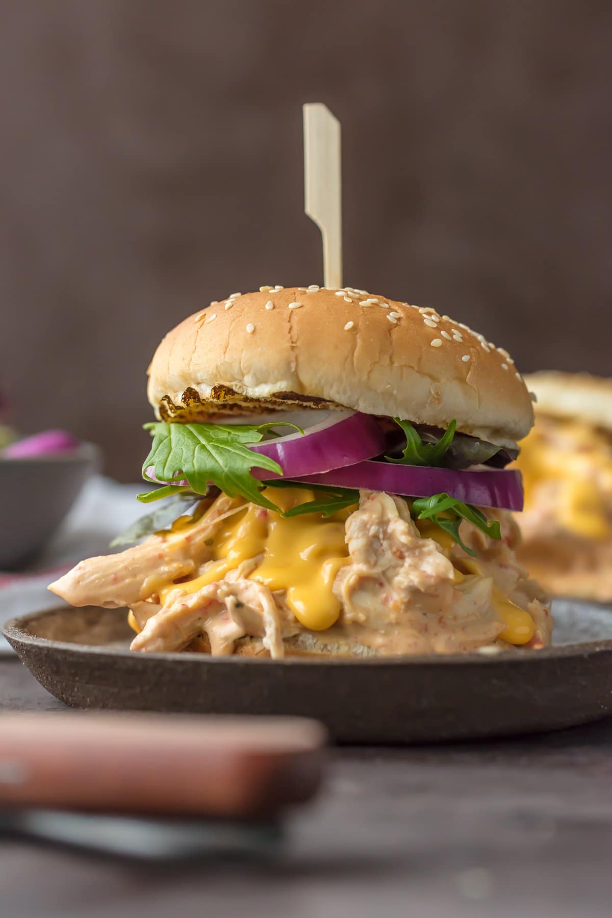 Chicken Rotel Sandwiches are the ultimate way to tailgate for the Super Bowl! These Slow Cooker Rotel Dip Chicken Sandwiches are the perfect mix of flavors. Spicy Cheesy Chicken Sandwiches made in the crock pot. So easy and so addicting! Chicken Rotel Sandwich