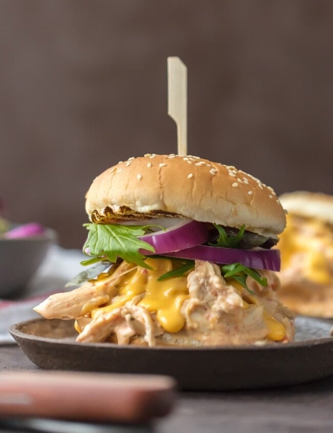 Chicken Rotel Sandwiches are the ultimate way to tailgate for the Super Bowl!  These Slow Cooker Rotel Dip Chicken Sandwiches are the perfect mix of flavors. Spicy Cheesy Chicken Sandwiches made in the crock pot. So easy and so addicting!