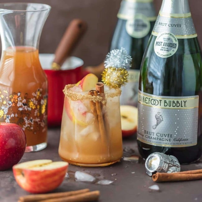 SPARKLING APPLE PIE ON THE ROCKS is the perfect Fall cocktail! Cinnamon Apple Cider mixed with Caramel Apple Simple Syrup and topped with bubbly champagne. This apple cider cocktail is the best holiday drink ever!