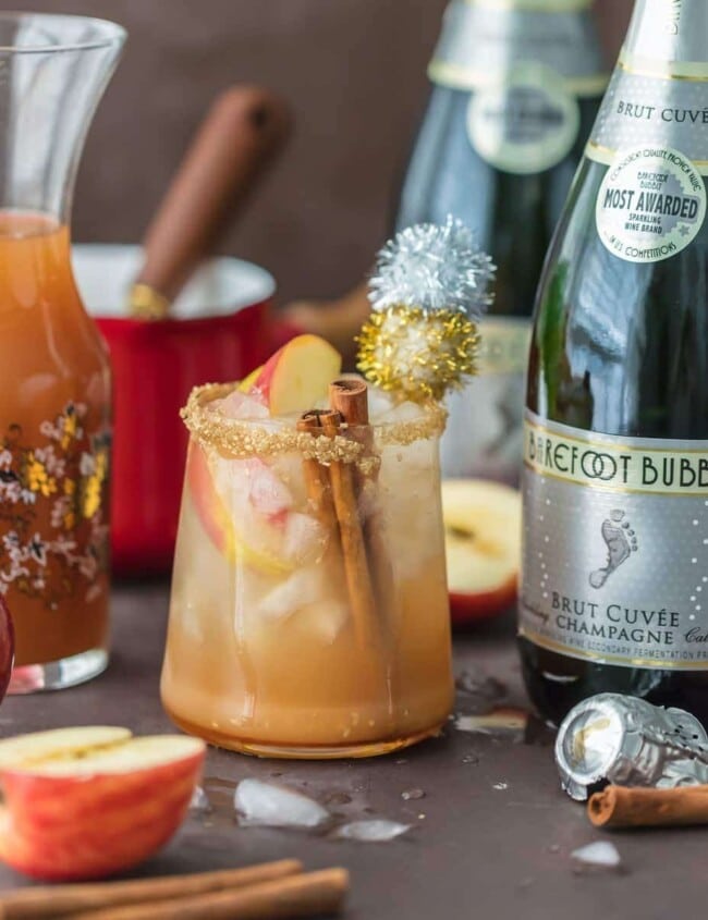 SPARKLING APPLE PIE ON THE ROCKS is the perfect Fall cocktail! Cinnamon Apple Cider mixed with Caramel Apple Simple Syrup and topped with bubbly champagne. This apple cider cocktail is the best holiday drink ever!