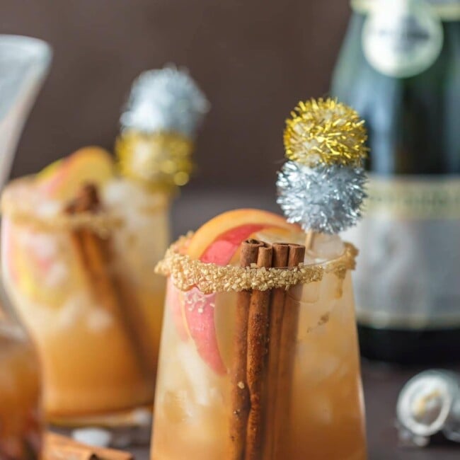 cocktails in glasses garnished with glitter pom poms