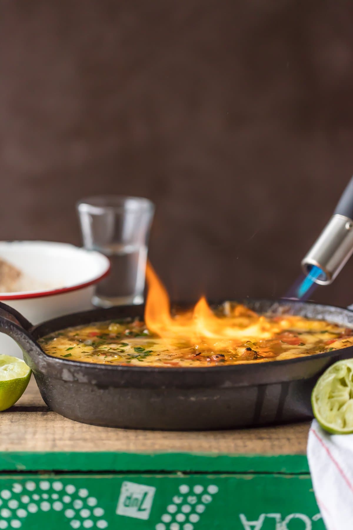 Lighting tequila lime queso on fire with a kitchen torch