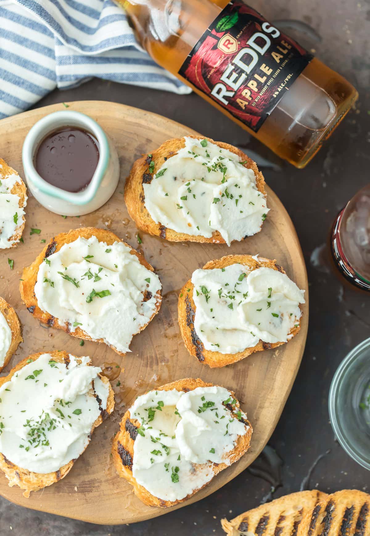 A wood serving platter with goat cheese crostini