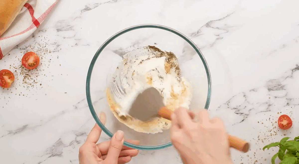 Combining sour cream and seasonings for the dip in a glass bowl. - 5