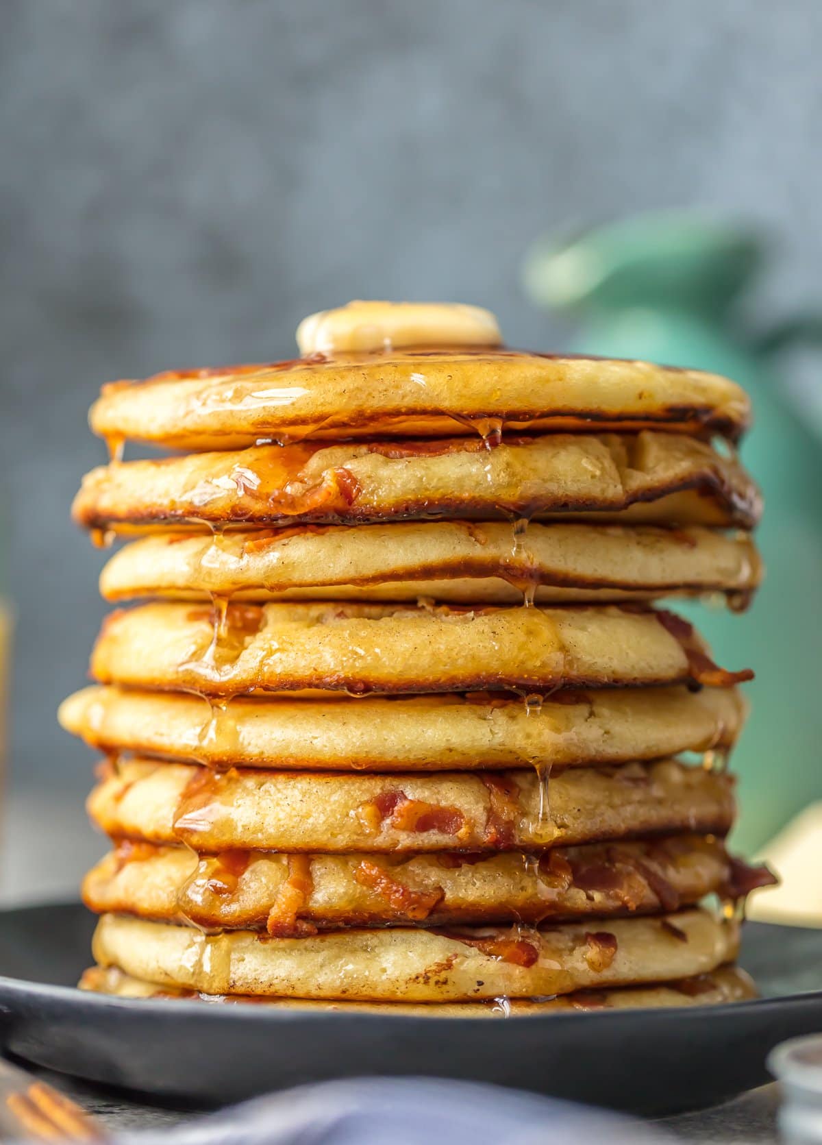 A stack of bacon pancakes covered in syrup