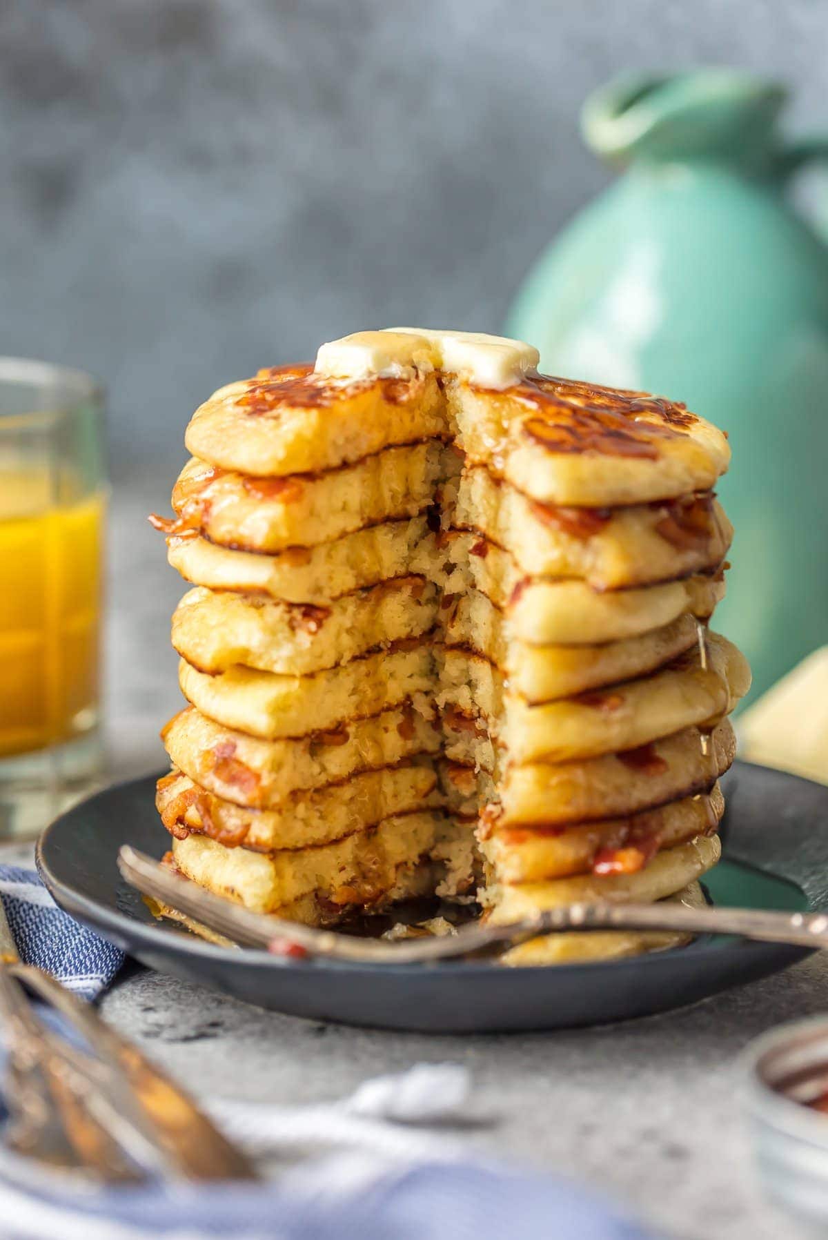 A stack of bacon pancakes with a slice taken out