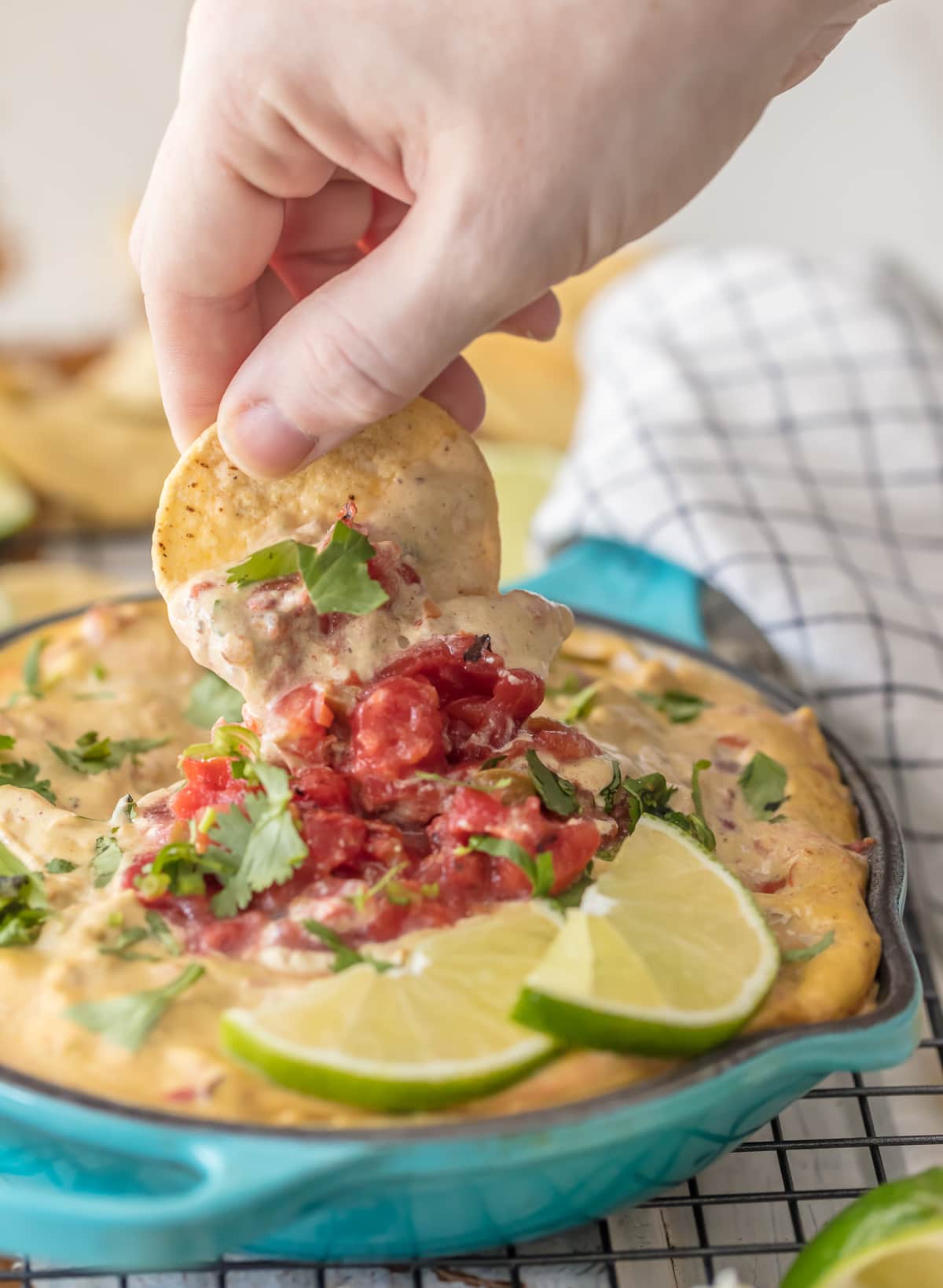 Dipping a chip into a bowl of vegan queso