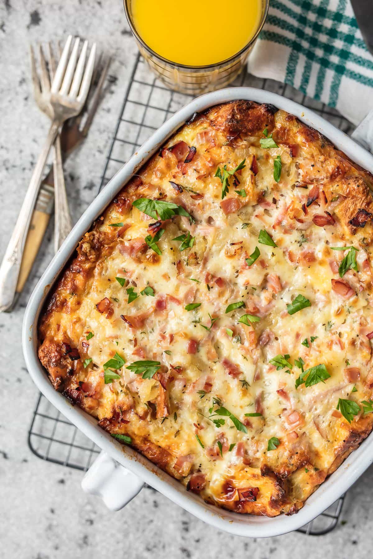 This HAM AND CHEESE BREAKFAST CASSEROLE is our favorite make ahead breakfast for any special occasion. This breakfast casserole with ham, cheese, bread, eggs, herbs, and more is sure to please everyone and just so easy to make! Ham and Cheese Breakfast Casserole in a baking dish