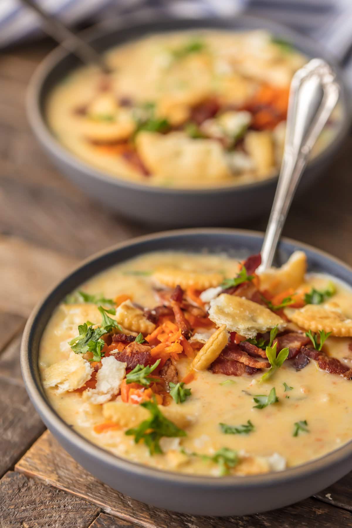 two bowls of potato cheese soup on a table