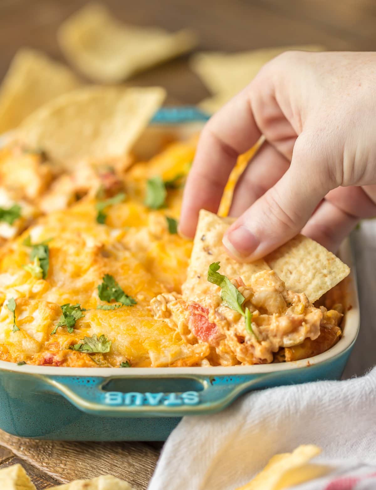 Dipping tortilla chips into King Ranch Chicken Dip