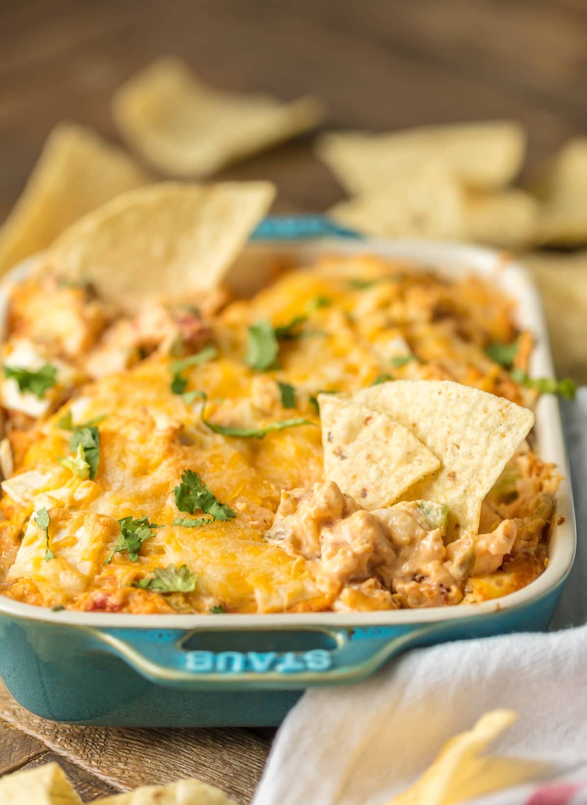 Hot dip recipe in a casserole dish, filled with cheese, chicken, green chiles, rotel, and more