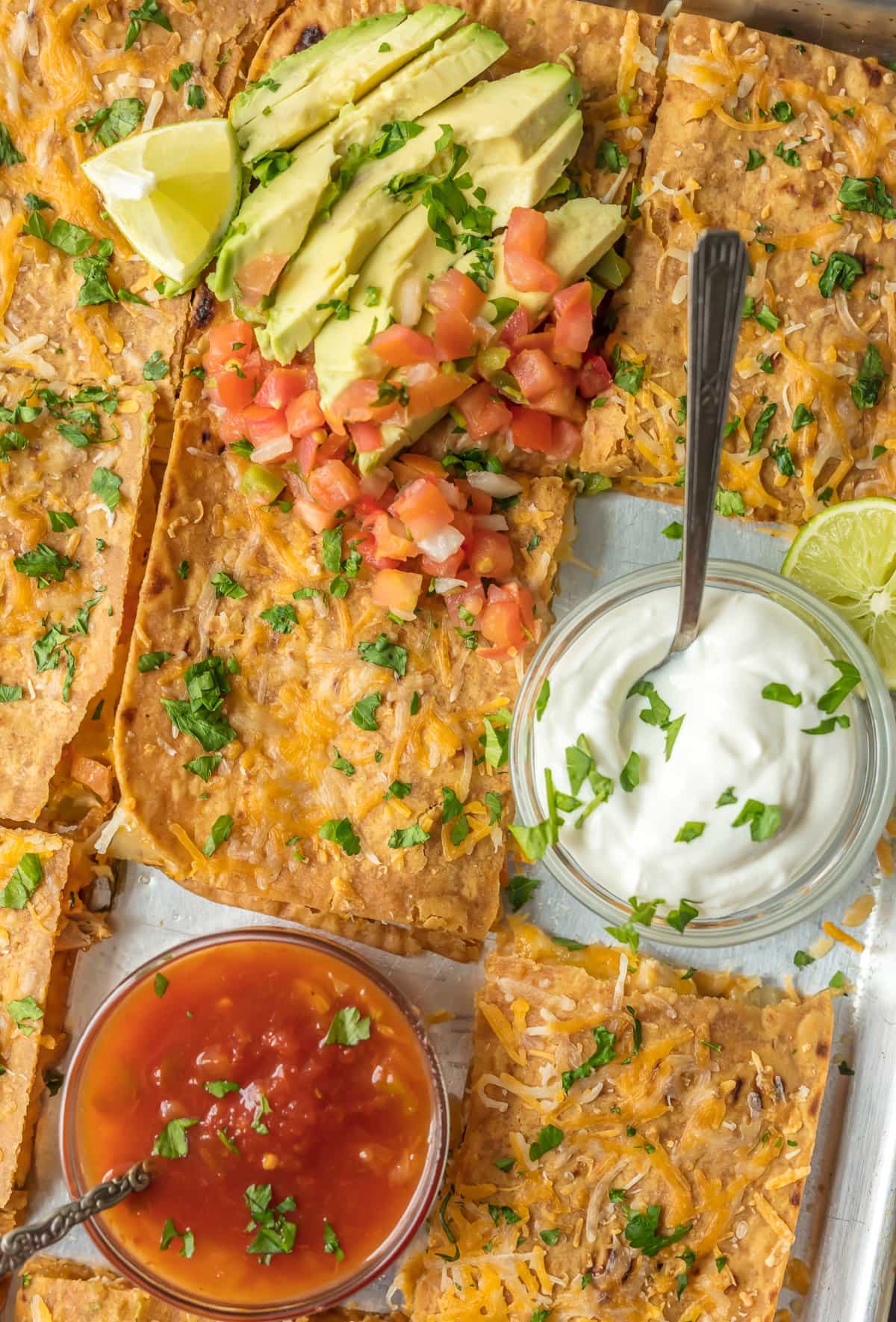 SHEET PAN CHICKEN QUESADILLAS are the easiest and best way to make delicious quesadillas for a crowd! These baked quesadillas can be made with any filling and toppings, and are sure to please even the pickiest eaters.