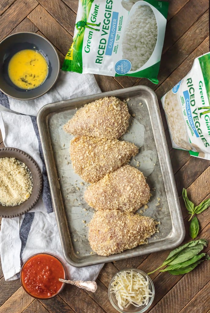 Chicken breast covered with parmesan crust, on a baking tray 