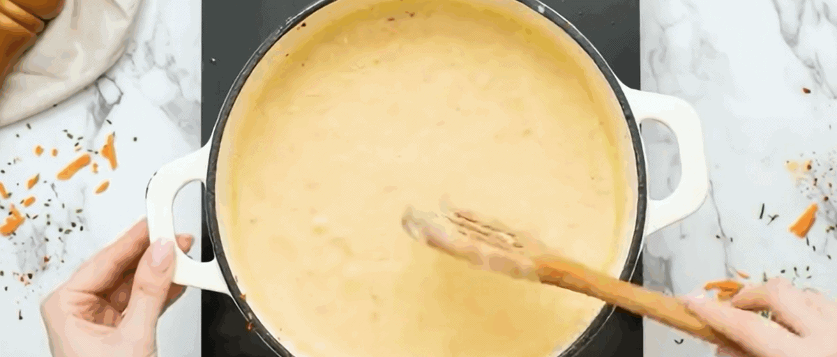 Adding cheese to the soup. 