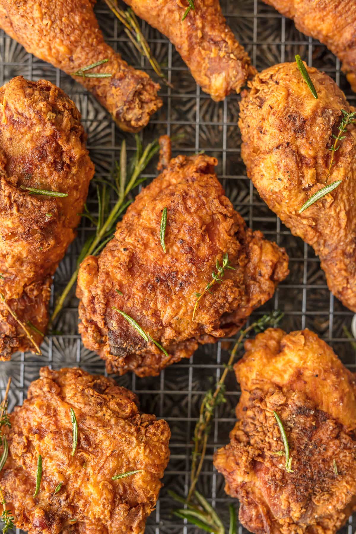 BUTTERMILK FRIED CHICKEN is the best fried chicken recipe you will ever sink your teeth into. Fried Chicken can be tricky, but we have broken it down to the PERFECT easy fried chicken recipe anyone can make. This Buttermilk Chicken Recipe will become the favorite chicken of your life! up close picture of fried chicken with rosemary