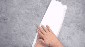 A person's hand is holding a piece of parchment.