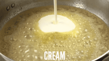 heavy cream poured into sauce in a saucepan.