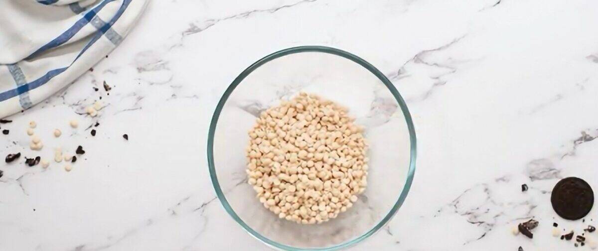 White chocolate chips and oil in a glass bowl.