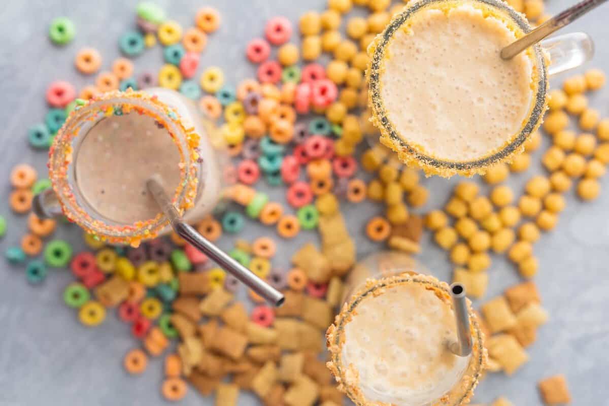 Cereal Milk Breakfast Smoothies (3 Ways!) are a fun, healthy, and easy breakfast the entire family with love! Blend your favorite cereal with milk, bananas, and ice and you're in business! Customizable for any flavor. SO FUN! overhead view of different breakfast cereals