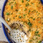 serving spoon inside blue baking dish with beef stroganoff casserole