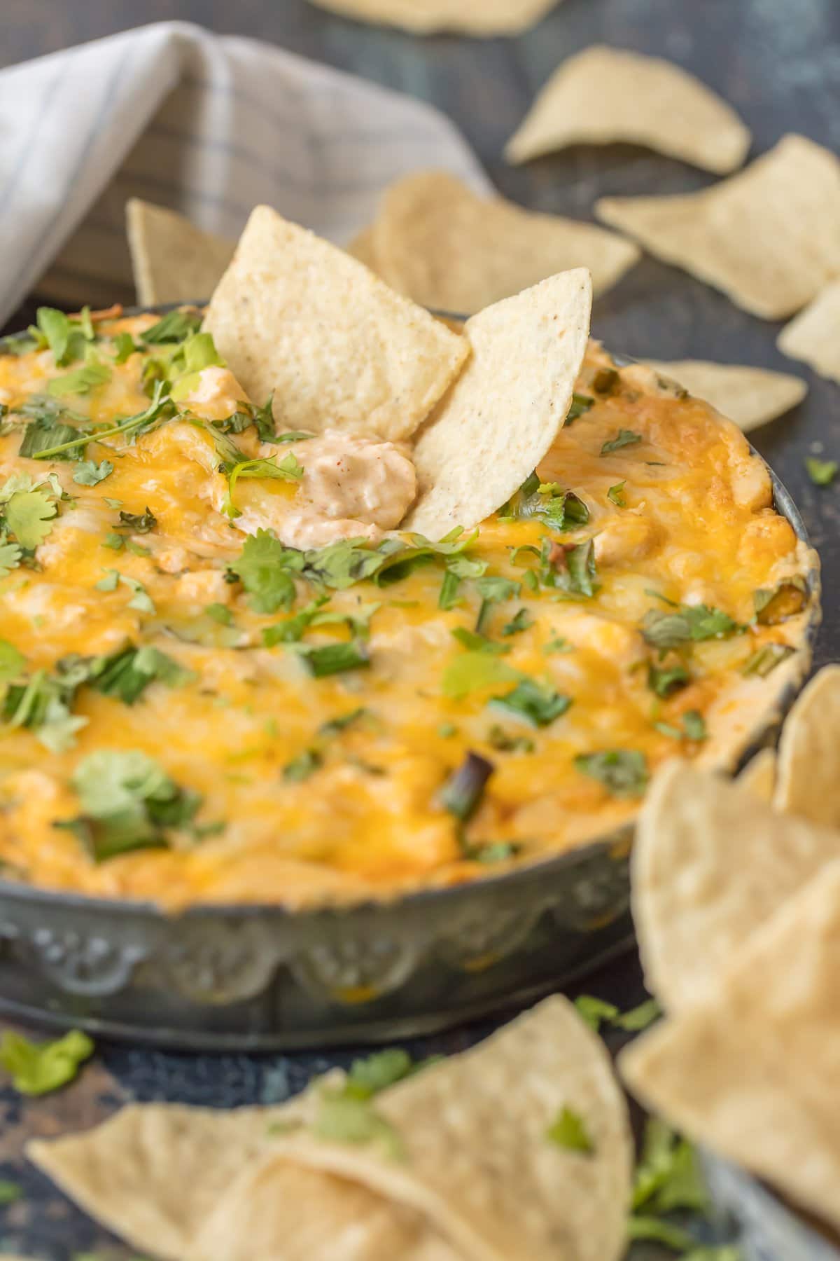 Two tortilla chips dipped into green chile dip