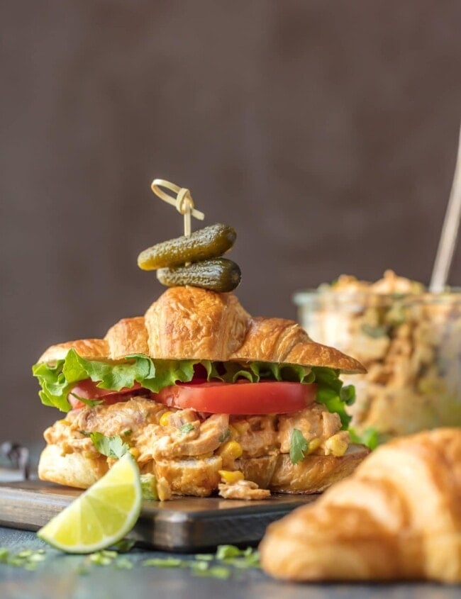 Make lunch spectacular with MEXICAN CHICKEN SALAD SANDWICHES! This easy twist on a classic is sure to please everyone at the table. Chicken salad loaded with taco seasoning, corn, peppers, and enchilada sauce. SO GOOD!