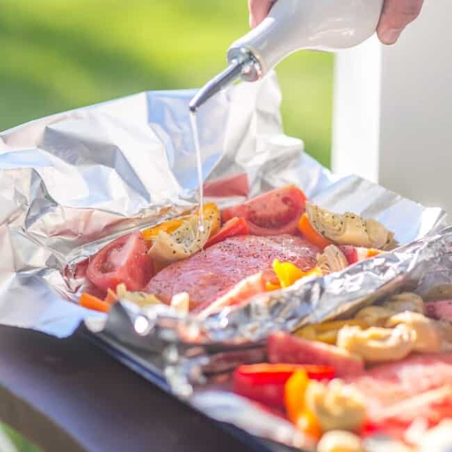 These GRILLED CAESAR SALMON FOIL PACKETS are the perfect way to enjoy seafood on the grill this Summer. Salmon, tomatoes, artichokes, and sweet pepper in foil...easiest most delicious dinner ever.