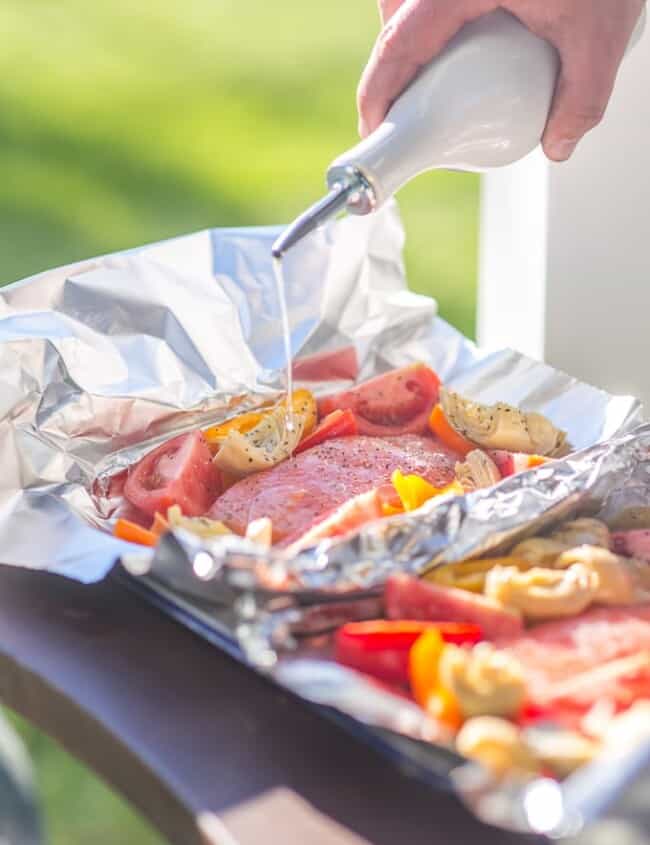 These GRILLED CAESAR SALMON FOIL PACKETS are the perfect way to enjoy seafood on the grill this Summer. Salmon, tomatoes, artichokes, and sweet pepper in foil...easiest most delicious dinner ever.