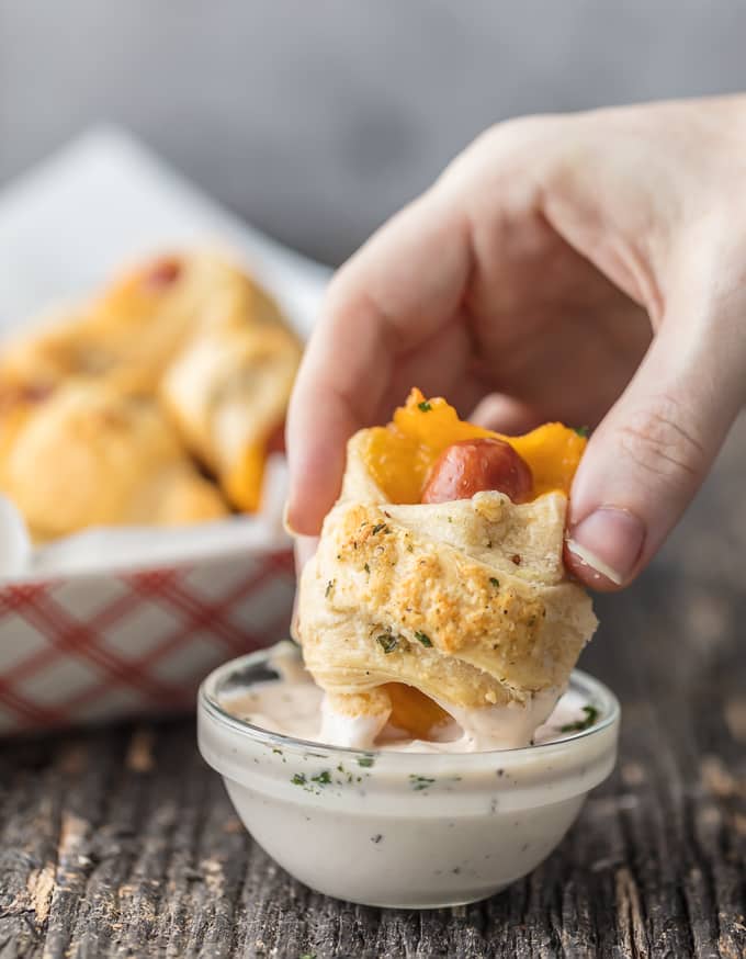 dipping cheesy pigs in a blanket in ranch sauce