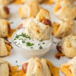 These CHEESY PIGS IN A BLANKET with RANCH PARMESAN BUTTER will be all the rage at your next party. They're easy, fun, and oh so delicious. Lil' Smokies wrapped in sharp cheddar, puff pastry, and brushed with parmesan ranch butter are sure to be a hit.