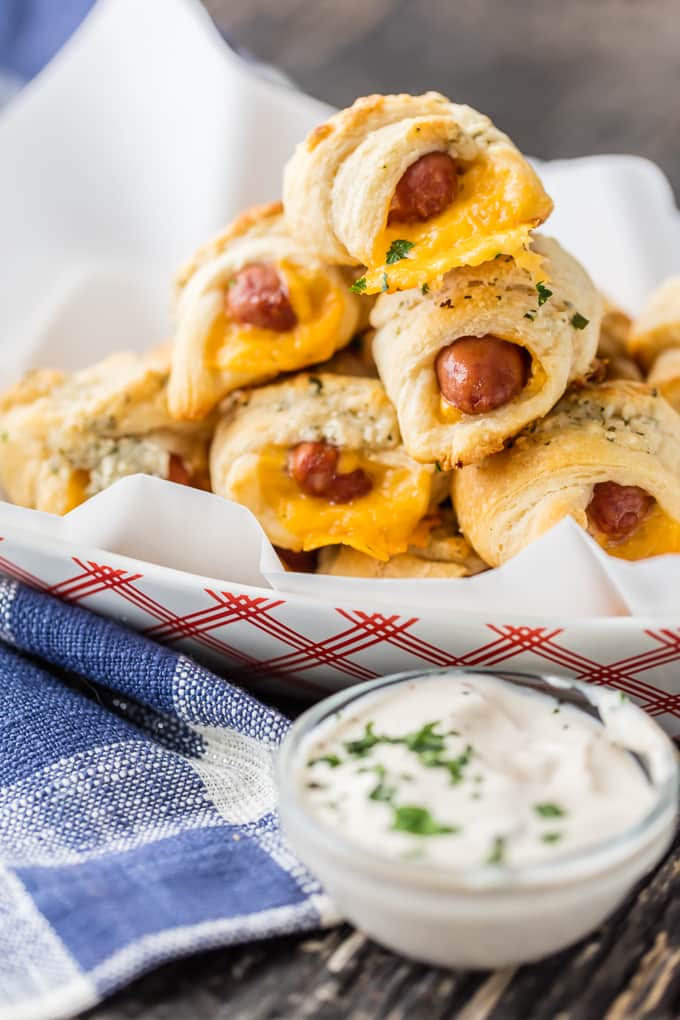 These CHEESY PIGS IN A BLANKET with RANCH PARMESAN BUTTER will be all the rage at your next party. They're easy, fun, and oh so delicious. Lil' Smokies wrapped in sharp cheddar, puff pastry, and brushed with parmesan ranch butter are sure to be a hit.