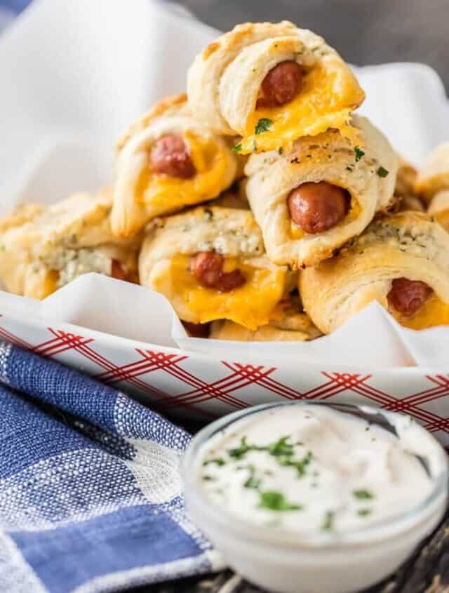 Hot dog crescent rolls on a plate with dipping sauce.