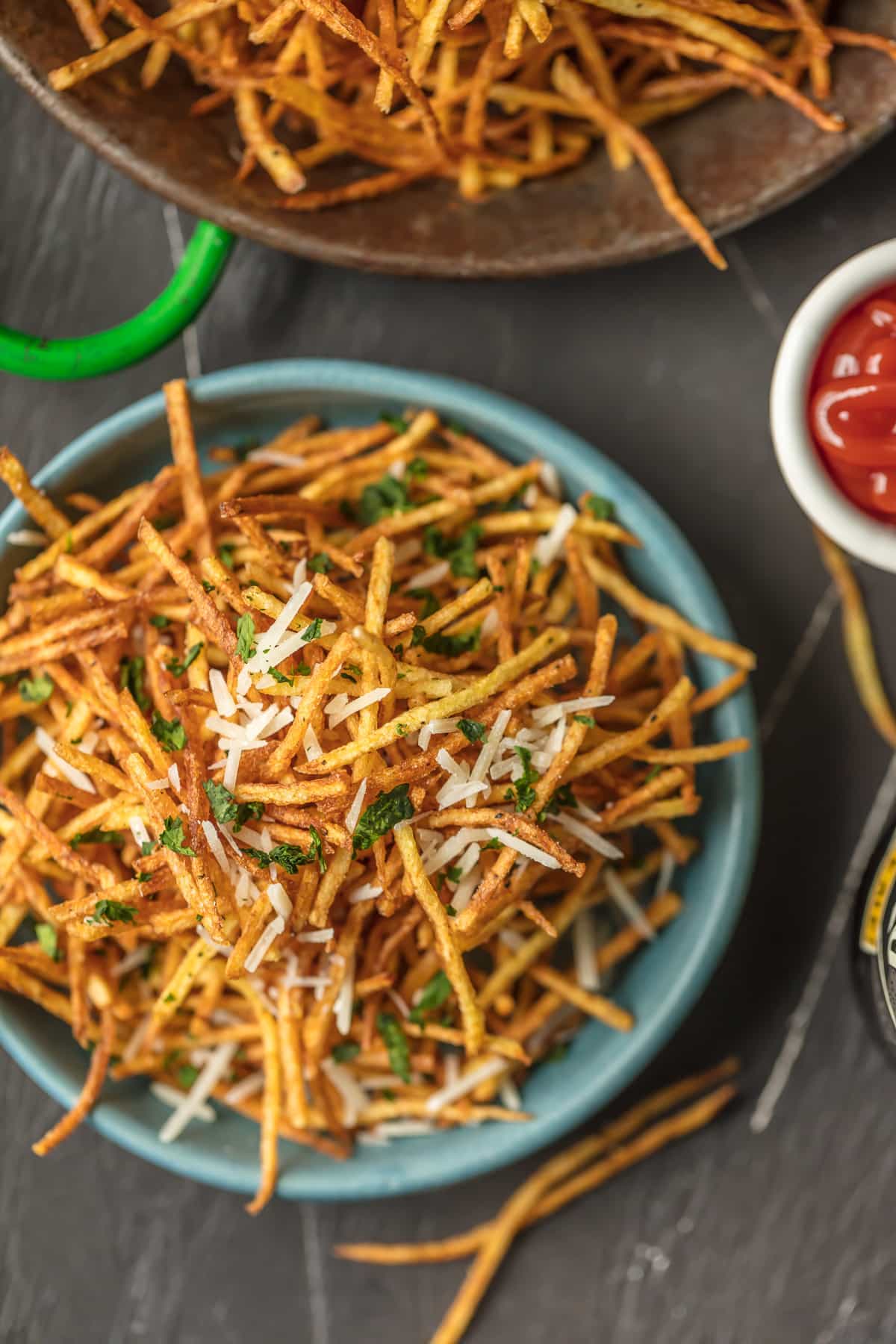 Shoestring Potatoes piled in a blue bowl.