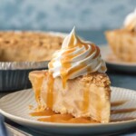 slice of pie on plate with whipped cream and caramel drizzled on top